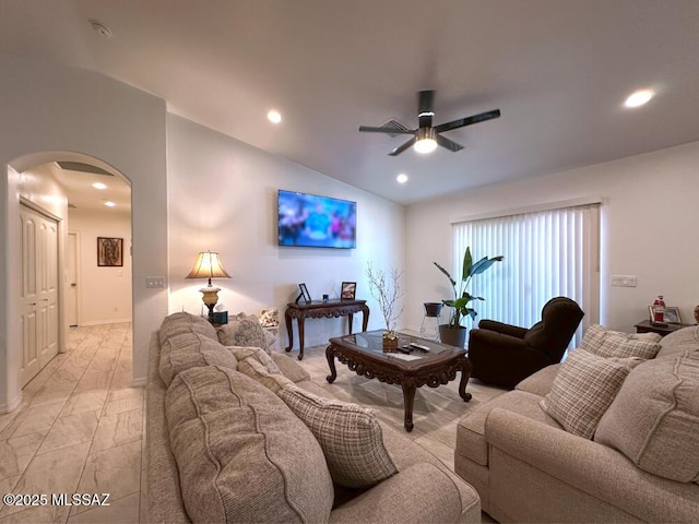 living room with vaulted ceiling, a ceiling fan, marble finish floor, arched walkways, and recessed lighting