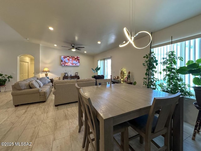 dining space with arched walkways, a ceiling fan, and recessed lighting