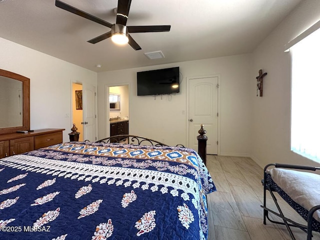 bedroom with baseboards, ensuite bath, visible vents, and ceiling fan