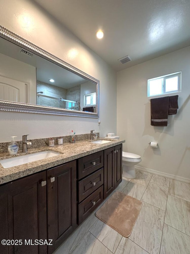 full bath featuring toilet, a sink, visible vents, and tiled shower