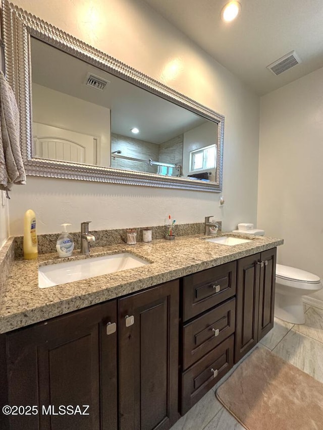 full bath with a sink, visible vents, and double vanity