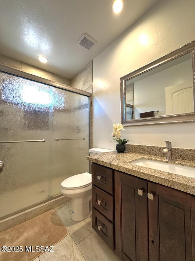 bathroom featuring a shower stall, visible vents, toilet, and vanity
