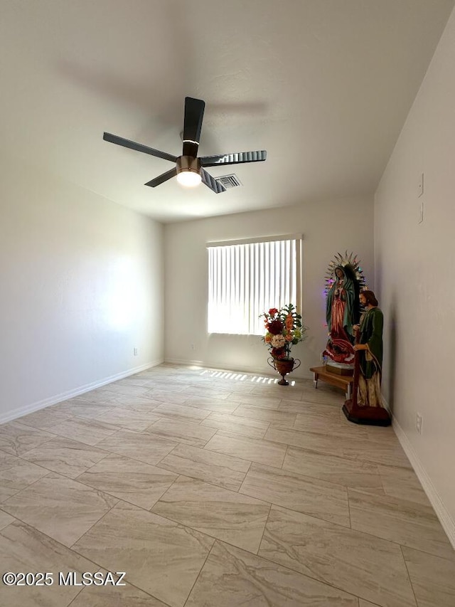 empty room with ceiling fan, baseboards, and visible vents