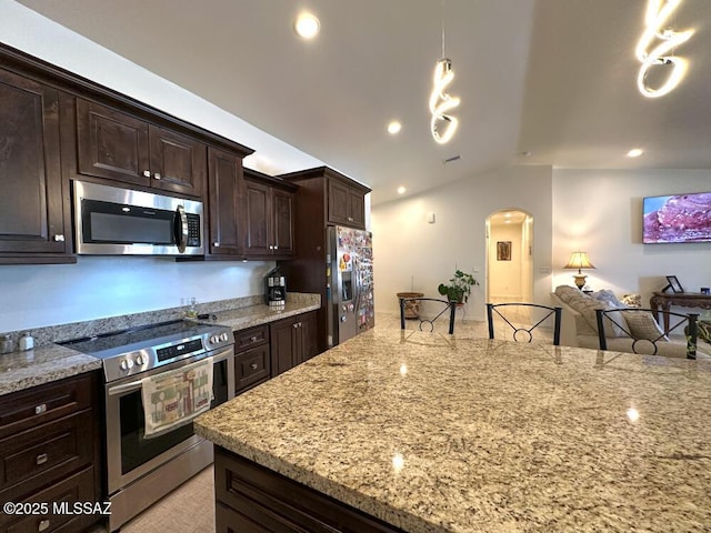 kitchen featuring vaulted ceiling, dark brown cabinets, open floor plan, arched walkways, and stainless steel appliances