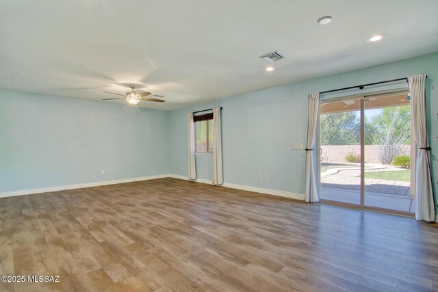 empty room featuring baseboards, visible vents, recessed lighting, a ceiling fan, and wood finished floors