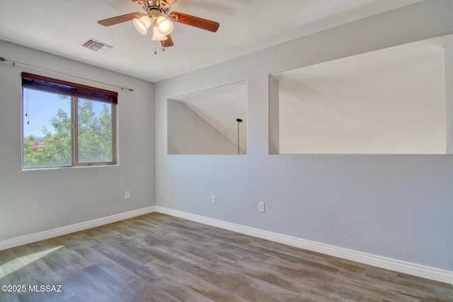 empty room with wood finished floors, visible vents, baseboards, and ceiling fan