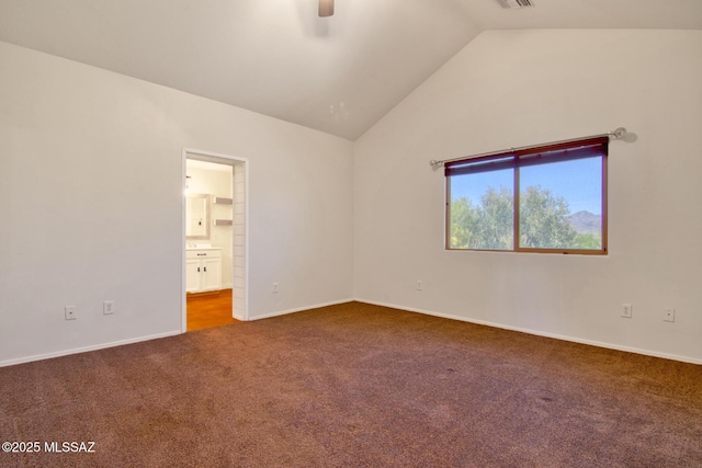 empty room with carpet, vaulted ceiling, visible vents, a ceiling fan, and baseboards