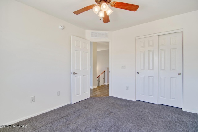 unfurnished bedroom featuring carpet, visible vents, a closet, baseboards, and ceiling fan