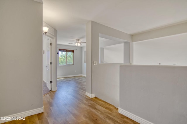hallway with wood finished floors and baseboards