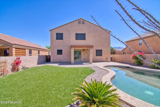 rear view of house featuring a yard, a patio area, a fenced backyard, and stucco siding