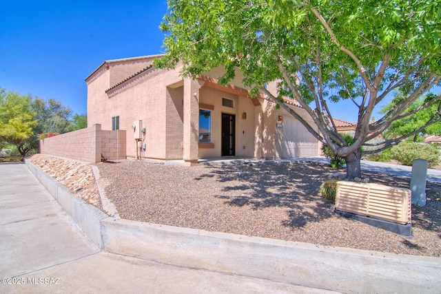 view of front of home featuring stucco siding, an attached garage, and a tiled roof