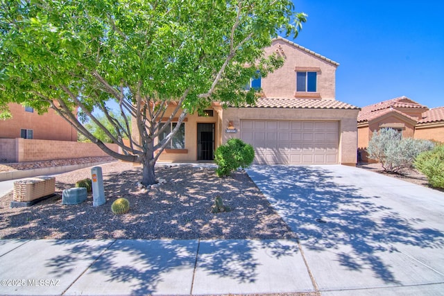 view of front of house with stucco siding, driveway, a tile roof, and fence