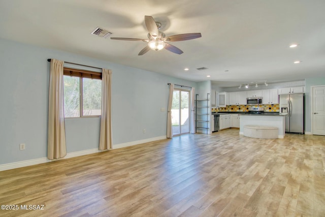 unfurnished living room featuring baseboards, a ceiling fan, visible vents, and light wood-style flooring