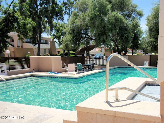 pool featuring fence and a patio area