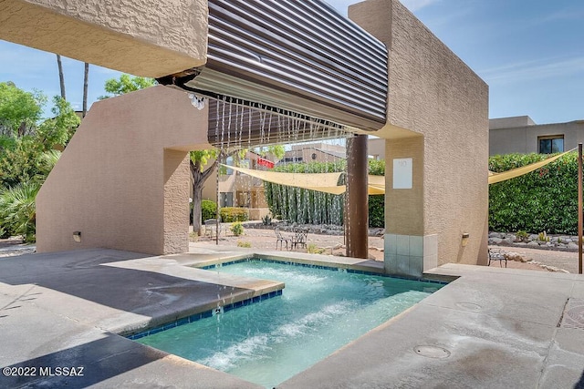view of swimming pool featuring a jacuzzi and a patio