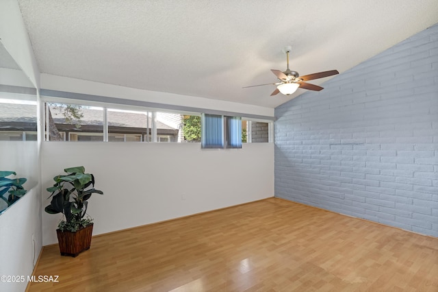 5701 E Glenn St Unit 61, Tucson, AZ 85712 - empty room with ceiling fan, brick wall, and wood finished floors
