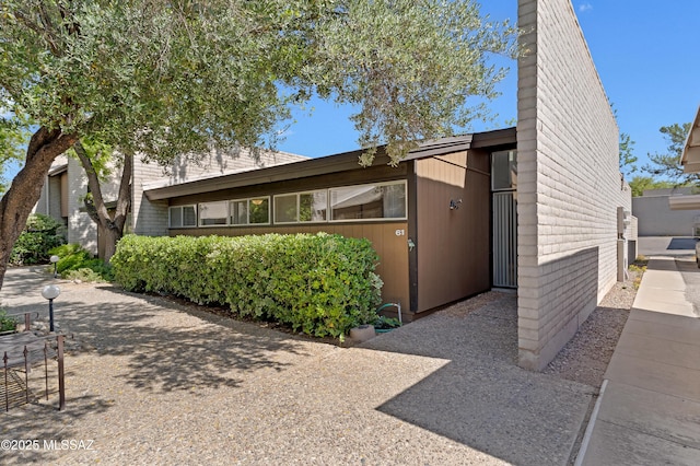 5701 E Glenn St Unit 61, Tucson, AZ 85712 - view of front facade with brick siding and a chimney