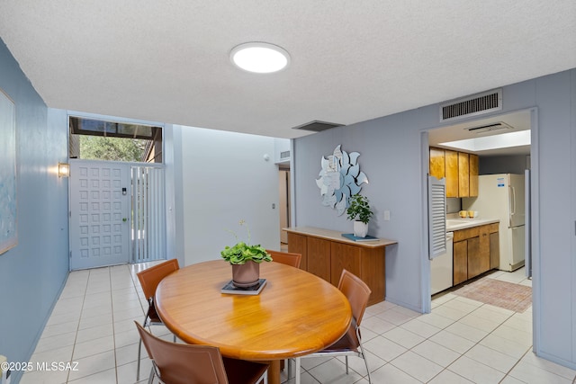 5701 E Glenn St Unit 61, Tucson, AZ 85712 - dining room featuring light tile patterned flooring, a textured ceiling, and visible vents
