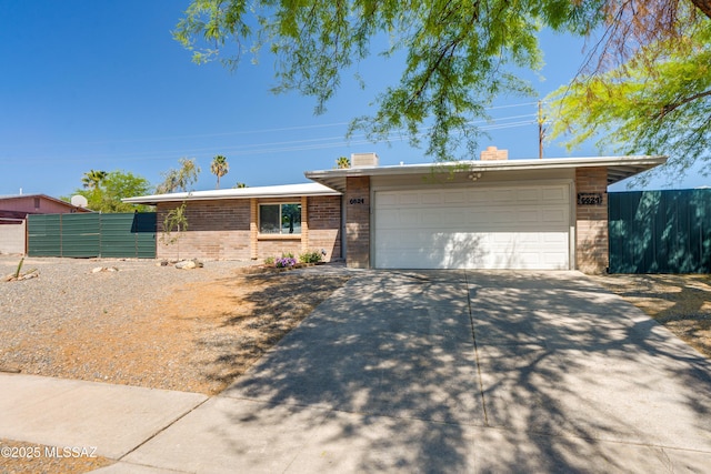 6624 N Galaxy Rd, Tucson, AZ 85741 - ranch-style home featuring a garage, fence, brick siding, and concrete driveway