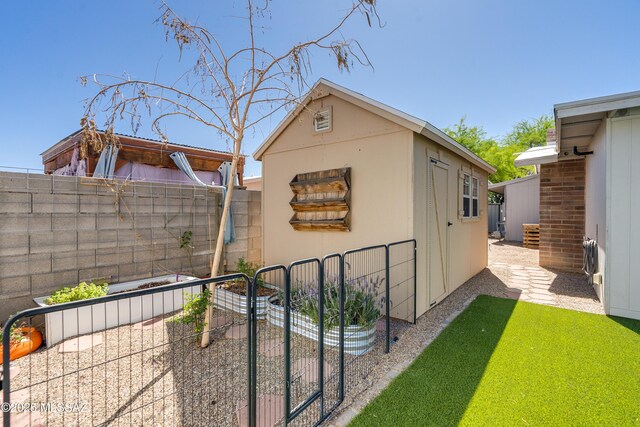 6624 N Galaxy Rd, Tucson, AZ 85741 - view of home's exterior with a fenced backyard, an outdoor structure, a garden, and stucco siding