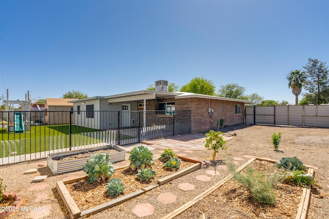 6624 N Galaxy Rd, Tucson, AZ 85741 - rear view of property featuring a gate, fence private yard, a garden, a yard, and brick siding