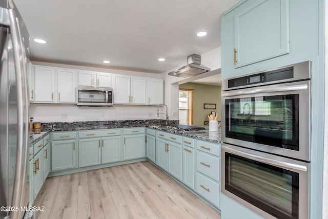 6624 N Galaxy Rd, Tucson, AZ 85741 - kitchen featuring recessed lighting, stainless steel appliances, dark stone countertops, light wood-style floors, and blue cabinetry