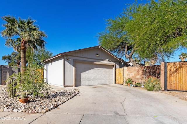 exterior space with fence, driveway, and a garage