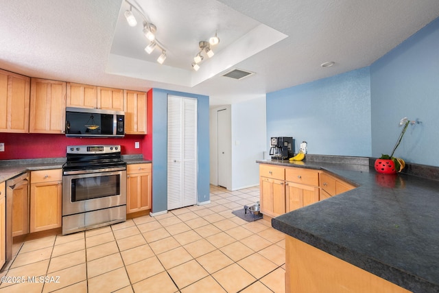 kitchen featuring light brown cabinets, stainless steel appliances, and visible vents