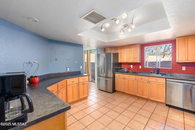 kitchen featuring stainless steel appliances, a tray ceiling, visible vents, a sink, and a textured ceiling