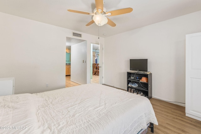 bedroom with light wood-type flooring, visible vents, and a ceiling fan