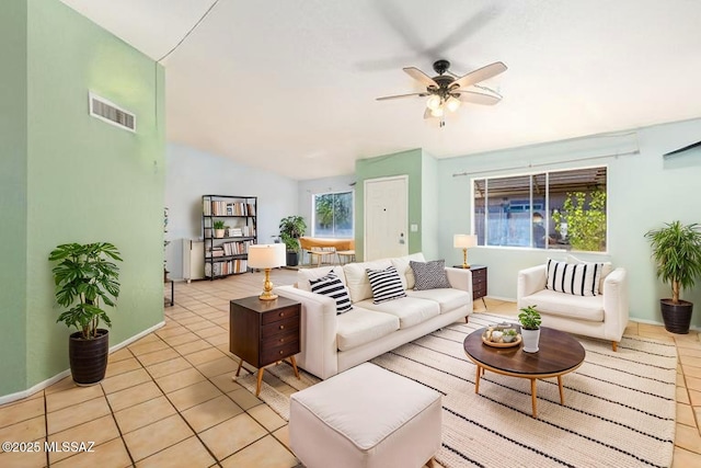 living area with vaulted ceiling, visible vents, light tile patterned floors, baseboards, and ceiling fan