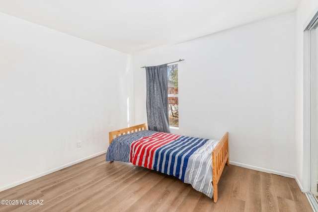 bedroom with baseboards and wood finished floors