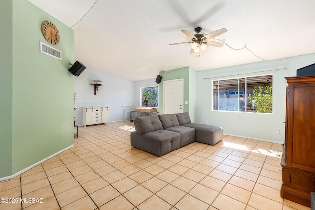 living area featuring baseboards, visible vents, lofted ceiling, a ceiling fan, and light tile patterned floors