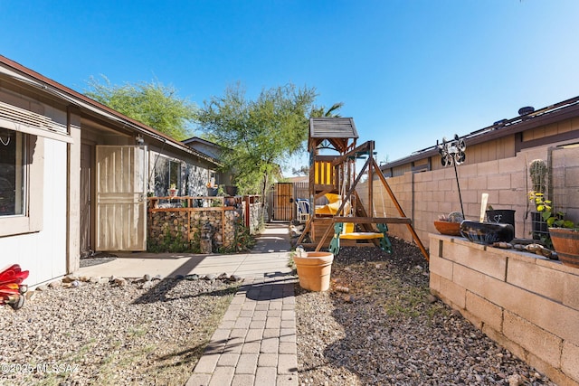 view of yard with a fenced backyard and a playground