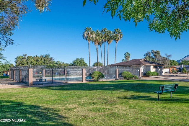 view of property's community with a lawn and fence