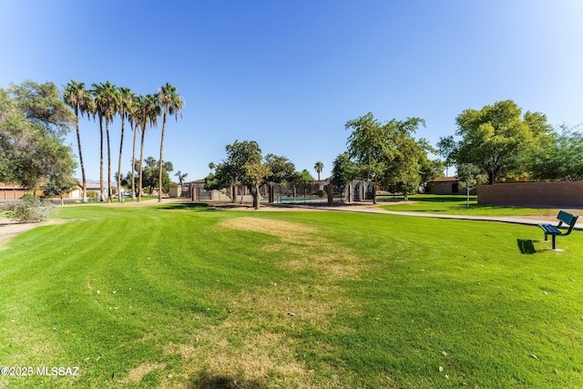 view of property's community with fence and a yard