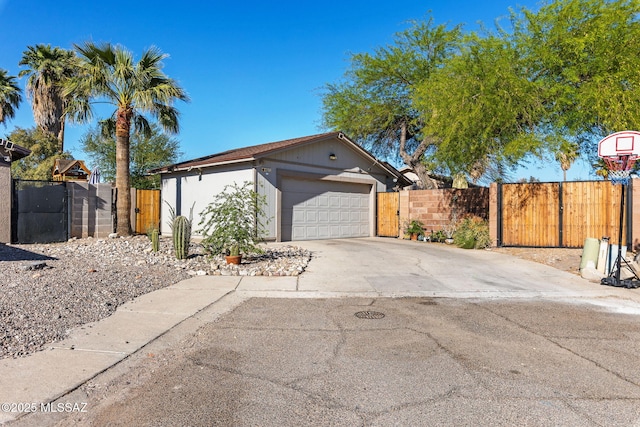view of side of property featuring a gate, concrete driveway, a garage, and fence