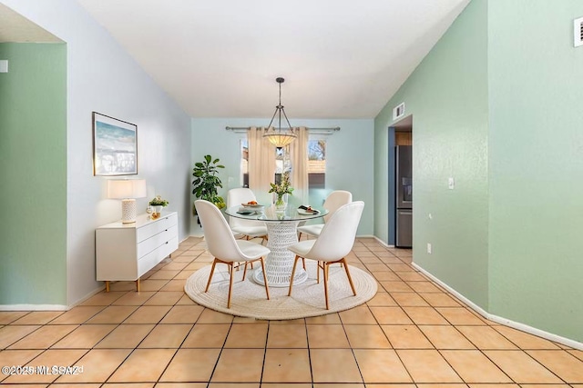 dining space featuring lofted ceiling, visible vents, baseboards, and light tile patterned floors