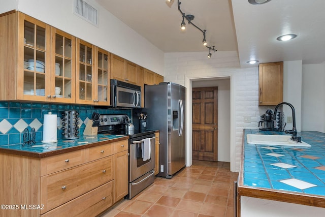 5122 W Camino De La Amapola, Tucson, AZ 85745 - kitchen featuring appliances with stainless steel finishes, a sink, tasteful backsplash, and tile countertops