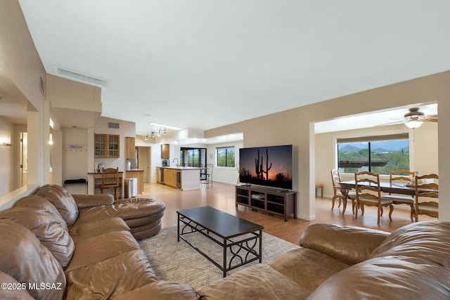 5122 W Camino De La Amapola, Tucson, AZ 85745 - living area featuring healthy amount of natural light, ceiling fan, a chandelier, and light wood finished floors