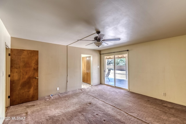 carpeted empty room with a ceiling fan