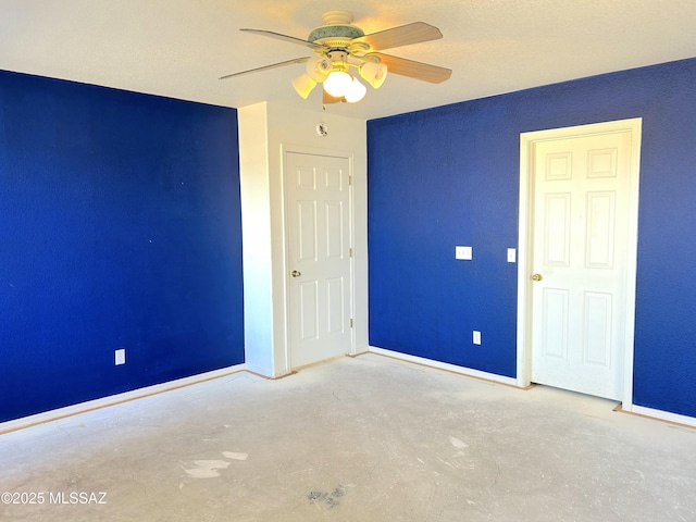 10211 E Hummingbird Meadow Way, Tucson, AZ 85747 - unfurnished bedroom with concrete floors, a ceiling fan, and baseboards