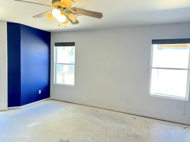 10211 E Hummingbird Meadow Way, Tucson, AZ 85747 - spare room with concrete floors, a ceiling fan, and baseboards