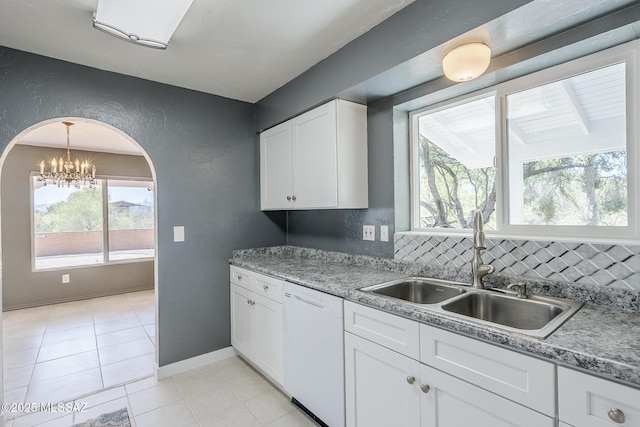 kitchen with white dishwasher, a sink, a healthy amount of sunlight, and white cabinetry