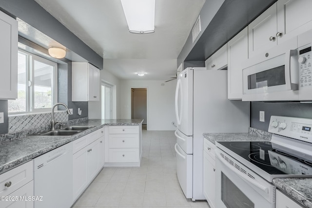 kitchen with visible vents, white appliances, white cabinetry, a sink, and light tile patterned floors