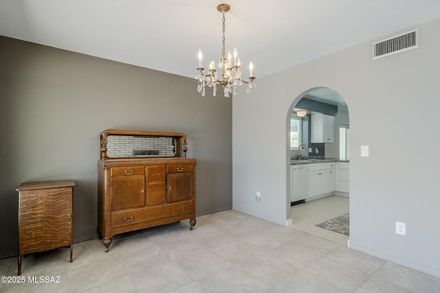 dining area with arched walkways, a notable chandelier, visible vents, and baseboards
