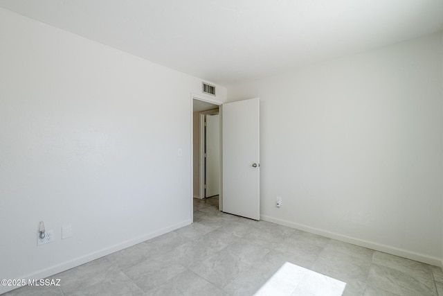 unfurnished room featuring baseboards and visible vents