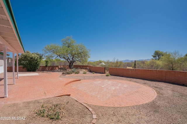 view of yard with a patio, a fenced backyard, and a mountain view