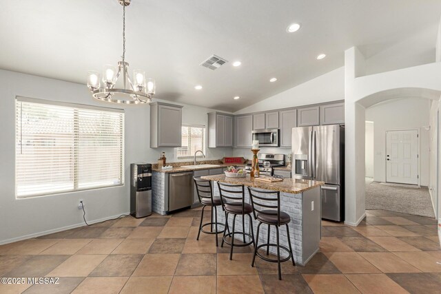 kitchen with gray cabinets, visible vents, appliances with stainless steel finishes, arched walkways, and a sink
