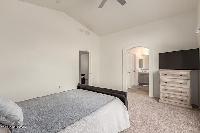 bedroom featuring light colored carpet, ensuite bath, arched walkways, high vaulted ceiling, and visible vents